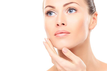 Frau fasst sich ins Gesicht